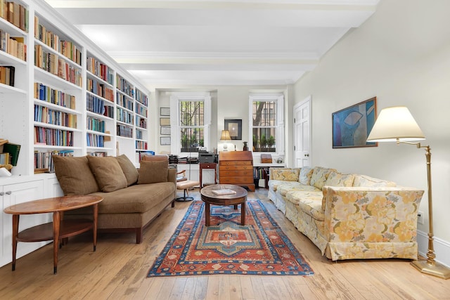living area with wood-type flooring and ornamental molding