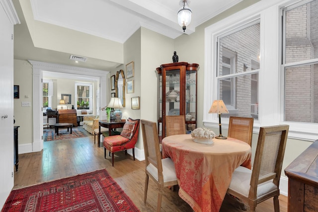 dining space with hardwood / wood-style floors and ornamental molding