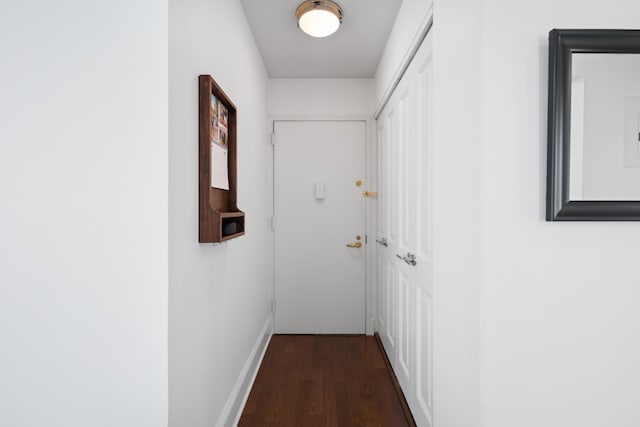 corridor with dark wood-style floors and baseboards