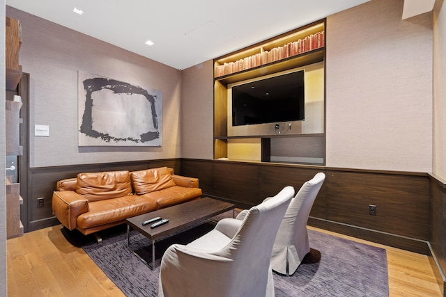 living room featuring light wood finished floors and a wainscoted wall