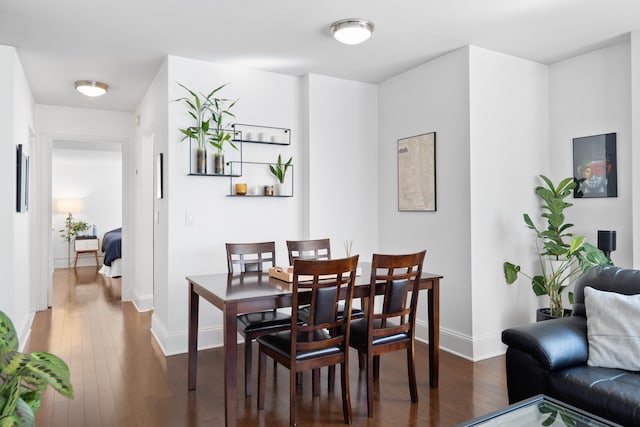 dining space featuring dark wood-style floors and baseboards