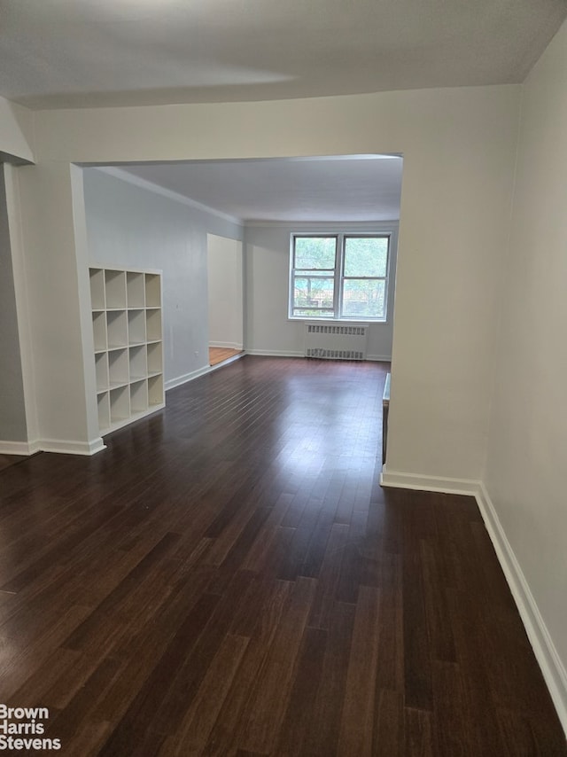 67-12 Yellowstone Blvd Unit C12, New York City, NY 11375 - empty room with radiator, dark wood-style flooring, baseboards, and built in shelves