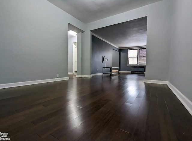 67-12 Yellowstone Blvd Unit C12, New York City, NY 11375 - unfurnished living room with dark wood-type flooring, baseboards, and radiator heating unit