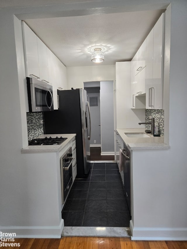 67-12 Yellowstone Blvd Unit C12, New York City, NY 11375 - kitchen with stainless steel microwave, oven, gas stovetop, decorative backsplash, and white cabinets