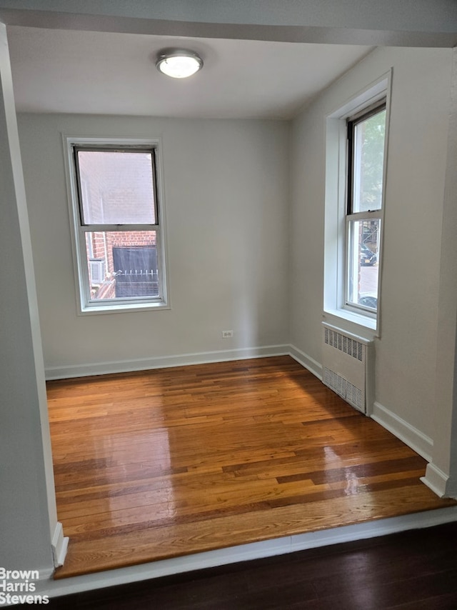 67-12 Yellowstone Blvd Unit C12, New York City, NY 11375 - empty room with radiator heating unit, wood finished floors, and baseboards