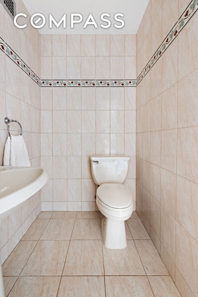 bathroom featuring tile walls, toilet, and tile patterned floors