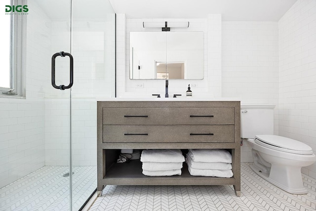 bathroom featuring vanity, a stall shower, tile walls, and toilet