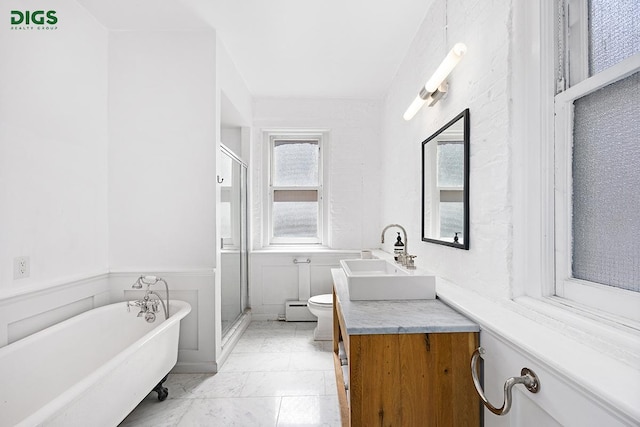bathroom featuring a baseboard radiator, toilet, a shower stall, a soaking tub, and wainscoting