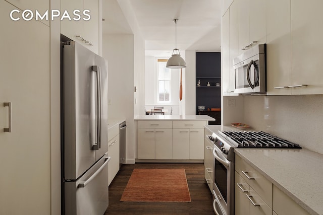 kitchen with stainless steel appliances, dark wood-type flooring, backsplash, pendant lighting, and white cabinetry