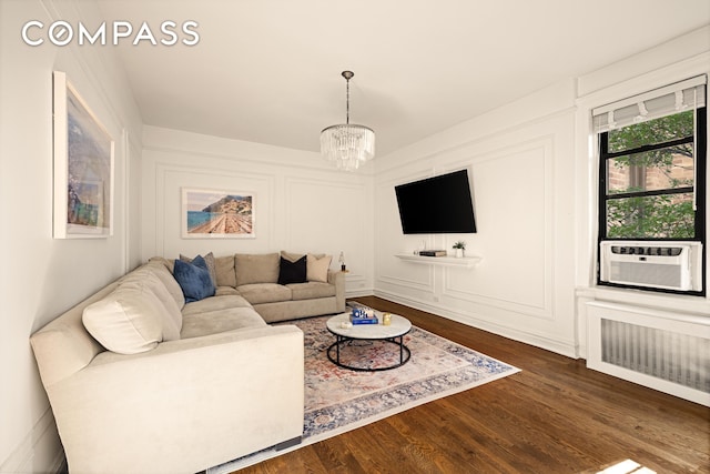 315 E 80th St Unit 2J, New York City, NY 10075 - living area featuring a chandelier, dark wood-style floors, cooling unit, and a decorative wall
