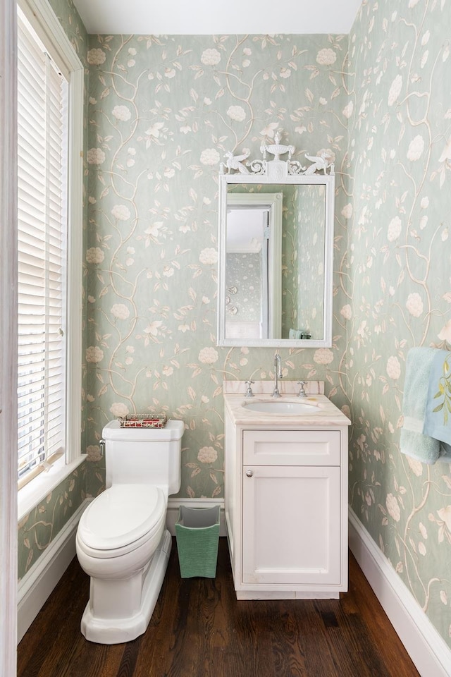 330 Convent Ave, New York City, NY 10031 - half bathroom featuring wood finished floors, wallpapered walls, toilet, baseboards, and vanity