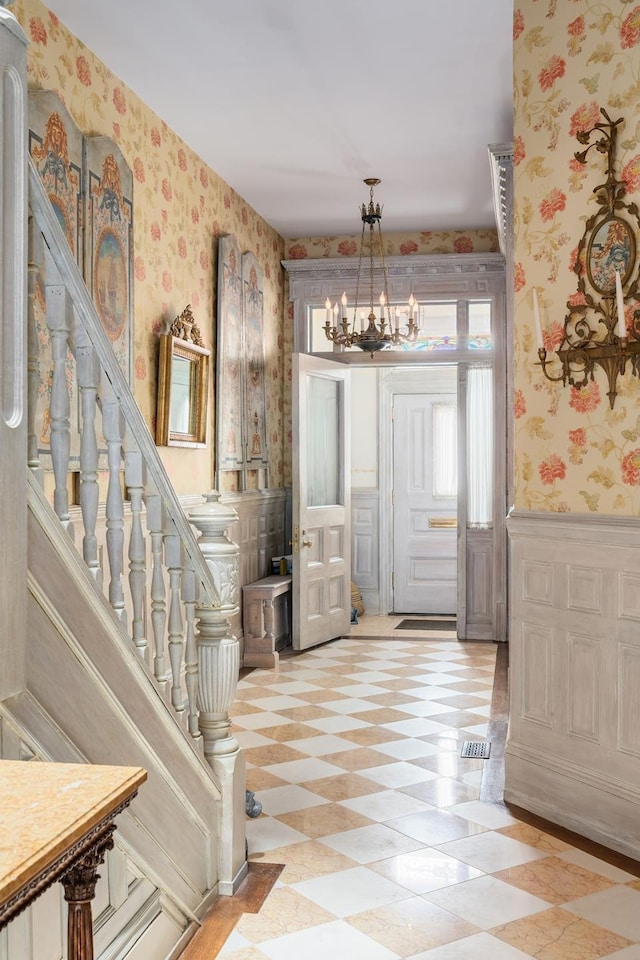 330 Convent Ave, New York City, NY 10031 - entrance foyer with wallpapered walls, a chandelier, a wainscoted wall, and light floors