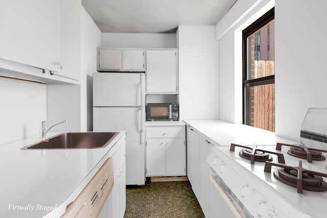 kitchen with white appliances, a sink, light countertops, and white cabinets