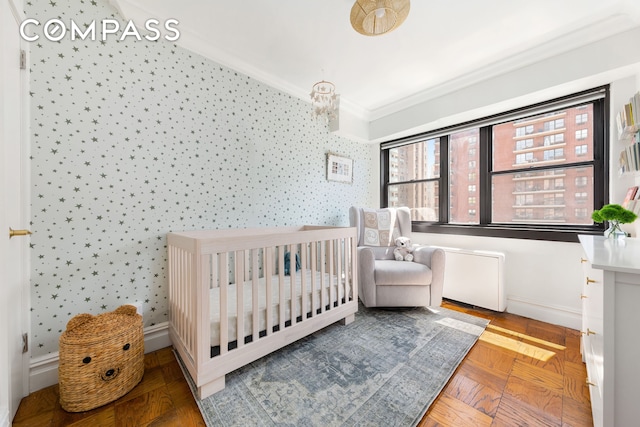 bedroom with crown molding, wallpapered walls, baseboards, and a nursery area