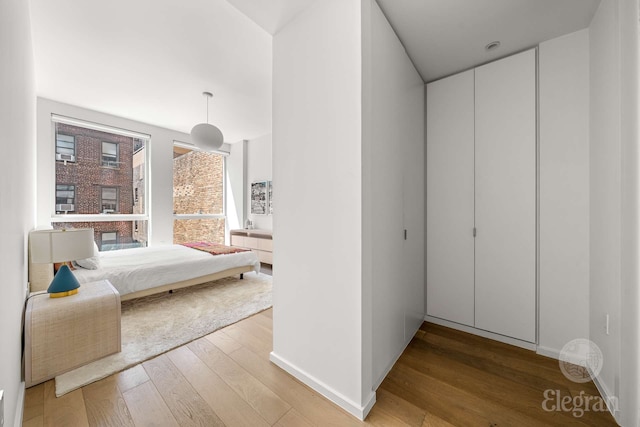 bedroom with light wood-style floors and baseboards