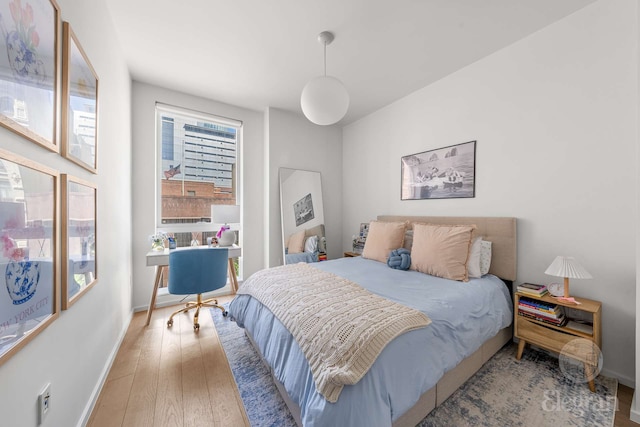 bedroom featuring wood finished floors and baseboards
