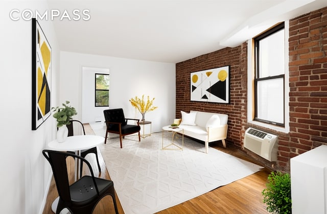 15 Jones St Unit 5H, New York City, NY 10014 - living area featuring wood finished floors, a wall unit AC, and brick wall