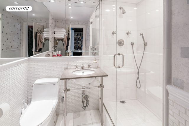233 E 69th St Unit 14Klm, New York City, NY 10021 - bathroom featuring a sink, toilet, tile walls, a shower stall, and tile patterned floors