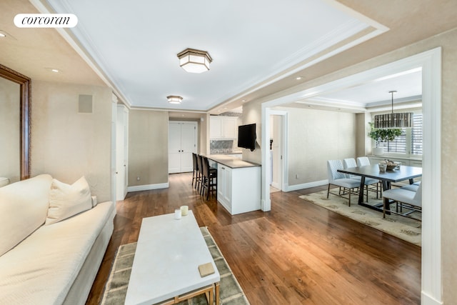 233 E 69th St Unit 14Klm, New York City, NY 10021 - living room featuring crown molding, dark wood-type flooring, baseboards, a tray ceiling, and a chandelier