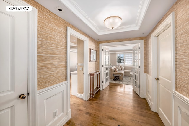 233 E 69th St Unit 14Klm, New York City, NY 10021 - hallway with a decorative wall, a wainscoted wall, ornamental molding, wood finished floors, and a tray ceiling
