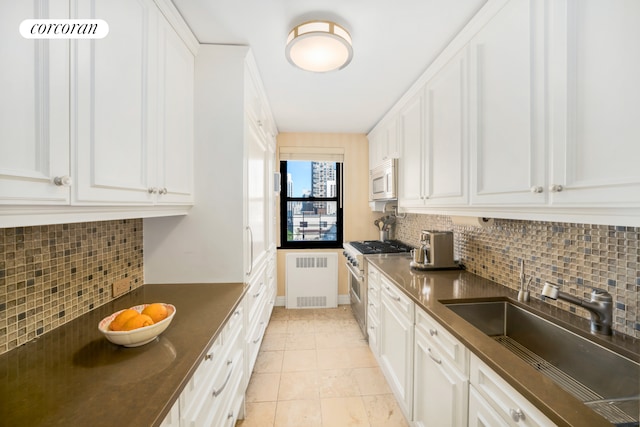 233 E 69th St Unit 14Klm, New York City, NY 10021 - kitchen with high end range, dark countertops, white microwave, backsplash, and white cabinets