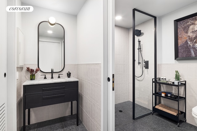 full bathroom featuring tile walls, walk in shower, wainscoting, vanity, and toilet