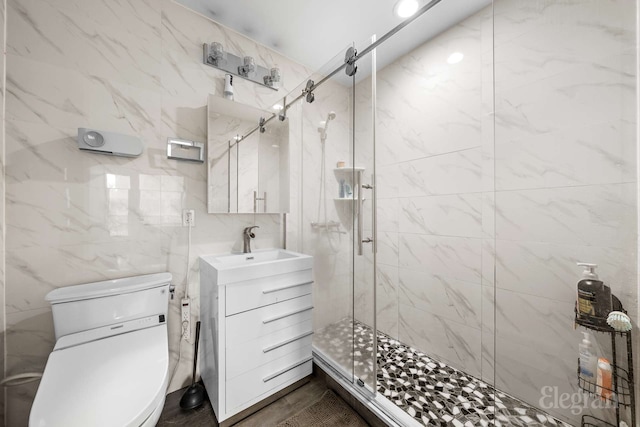 bathroom featuring a stall shower, tile walls, vanity, and toilet
