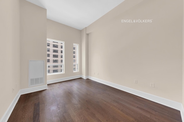 unfurnished room with dark wood-style floors and baseboards