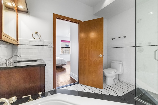 133 W 14th St Unit 6Ph, New York City, NY 10011 - ensuite bathroom with tile walls, a shower stall, toilet, vanity, and tile patterned floors