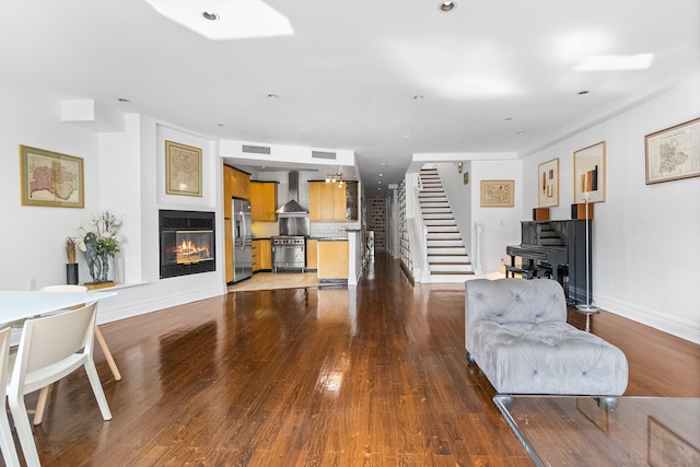 133 W 14th St Unit 6Ph, New York City, NY 10011 - living room with stairway, a glass covered fireplace, wood finished floors, and baseboards