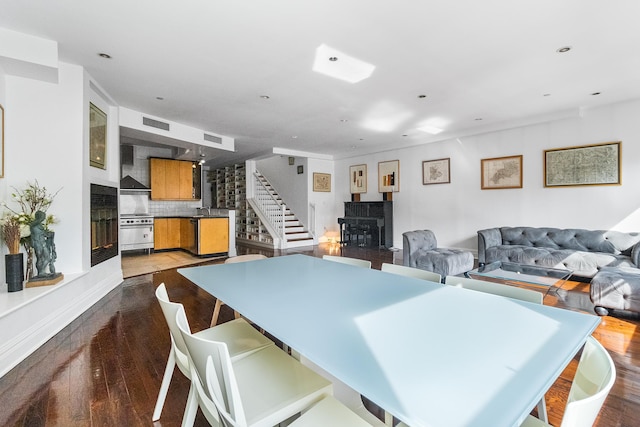 133 W 14th St Unit 6Ph, New York City, NY 10011 - dining room featuring stairway, dark wood-style floors, a fireplace, and recessed lighting