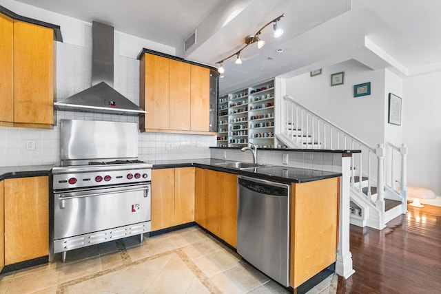 133 W 14th St Unit 6Ph, New York City, NY 10011 - kitchen with stainless steel appliances, wall chimney range hood, a peninsula, a sink, and tasteful backsplash