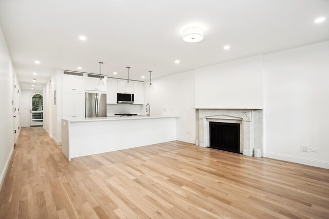119 Henry St Unit 1, New York City, NY 11201 - unfurnished living room with light wood-style flooring, recessed lighting, baseboards, and a fireplace