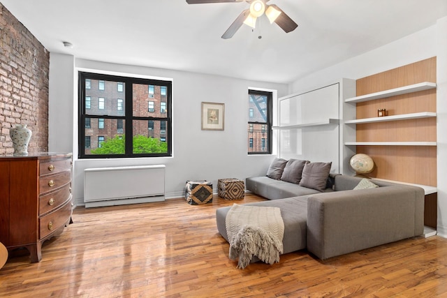 410 W 23rd St Unit 4E, New York City, NY 10011 - living area featuring a ceiling fan, wood finished floors, and a baseboard radiator