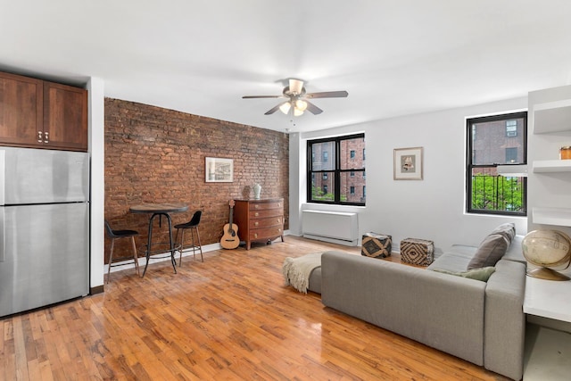 410 W 23rd St Unit 4E, New York City, NY 10011 - living room with a ceiling fan, brick wall, and light wood finished floors