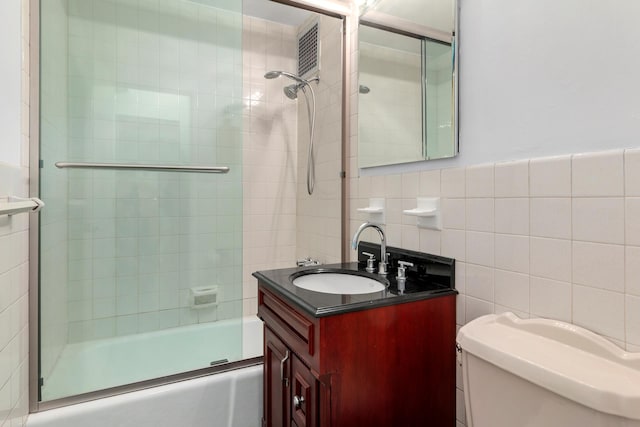 410 W 23rd St Unit 4E, New York City, NY 10011 - bathroom with tile walls, enclosed tub / shower combo, toilet, and vanity