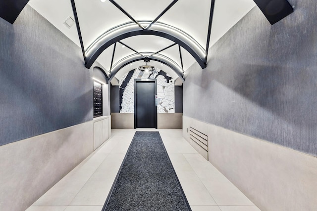 410 W 23rd St Unit 4E, New York City, NY 10011 - corridor featuring tile patterned flooring, lofted ceiling, and arched walkways