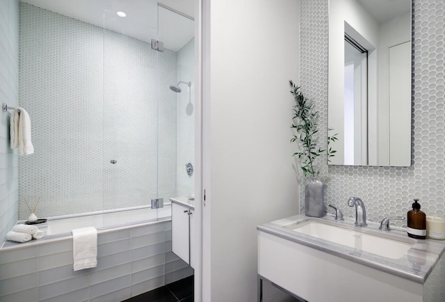 full bathroom featuring a tile shower and vanity
