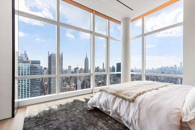460 W 42nd St Unit Ph-1C, New York City, NY 10036 - bedroom featuring a view of skyline, wood finished floors, and expansive windows