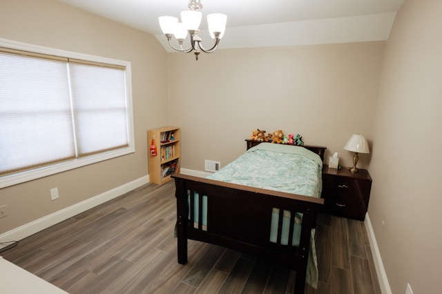bedroom with wood finished floors, a chandelier, and baseboards