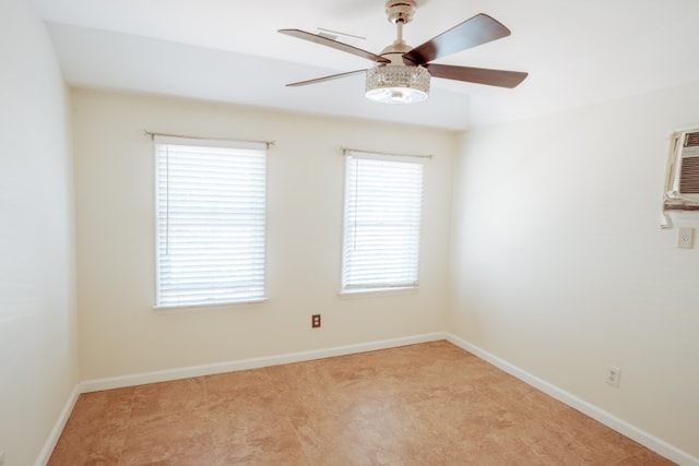 spare room featuring a ceiling fan, light carpet, baseboards, and an AC wall unit