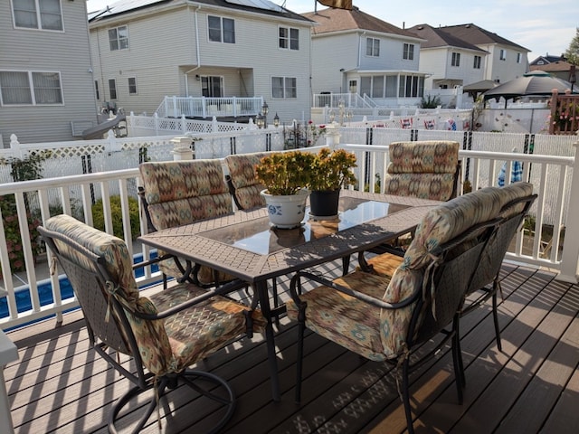 deck featuring outdoor dining area, a residential view, and fence