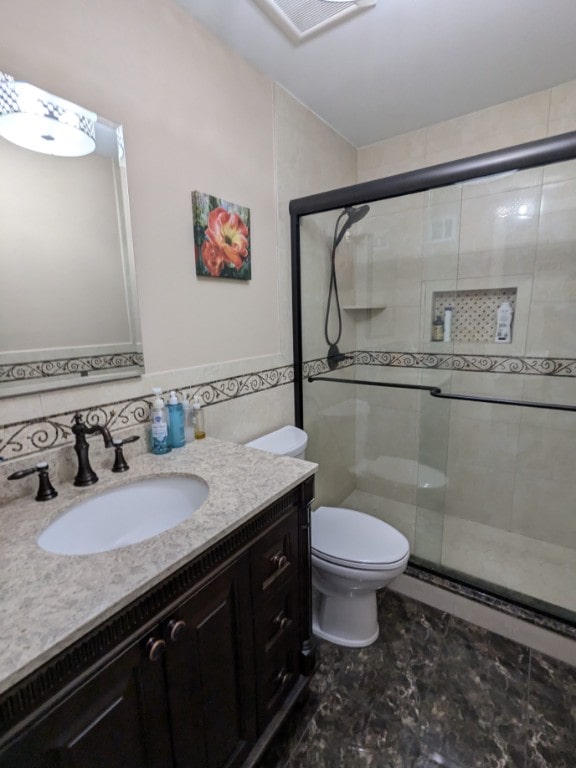 full bathroom with a shower stall, vanity, and toilet