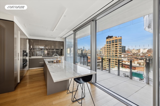 565 Broome St Unit S16B, New York City, NY 10013 - kitchen with a city view, a sink, light wood-style flooring, and a center island with sink