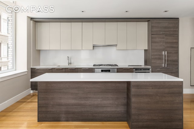 101 Leonard St Unit 2E, New York City, NY 10013 - kitchen with modern cabinets, baseboards, a sink, light countertops, and plenty of natural light
