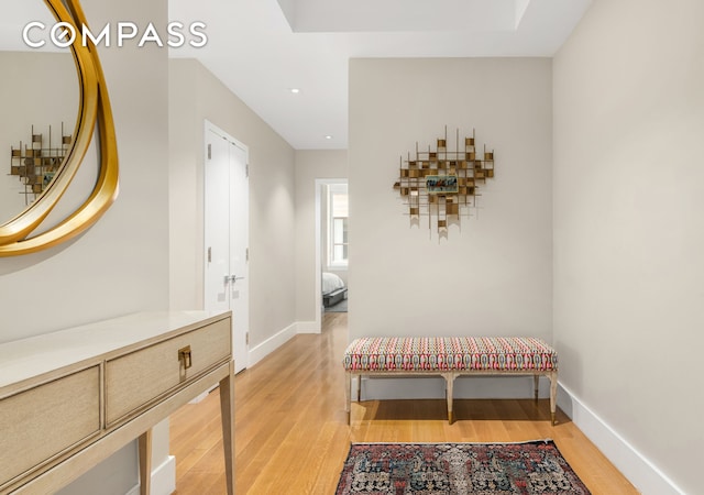 hallway with light wood-style floors, baseboards, and recessed lighting