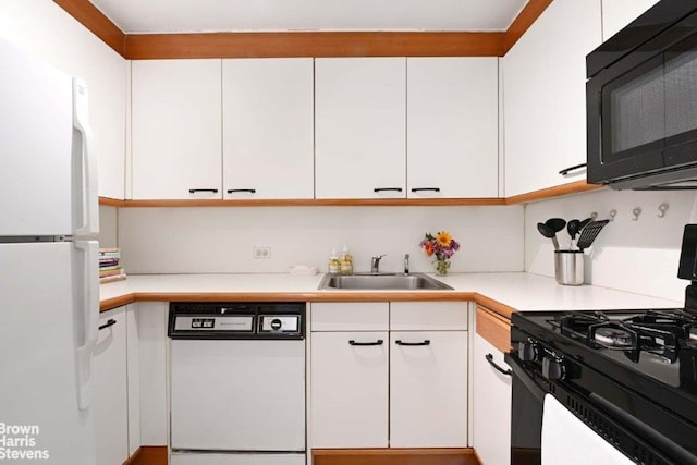 188 E 70th St Unit 16B, New York City, NY 10021 - kitchen featuring black appliances, a sink, and white cabinetry