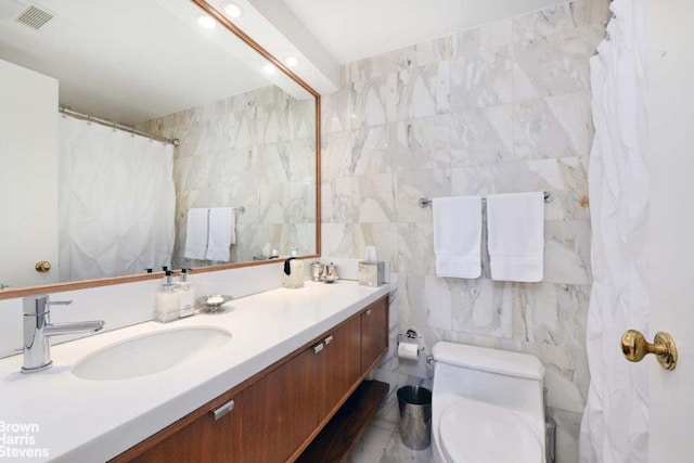 188 E 70th St Unit 16B, New York City, NY 10021 - bathroom featuring tile walls, vanity, and toilet