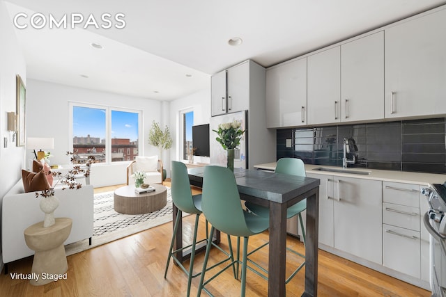 139 Skillman Ave Unit 7B, New York City, NY 11211 - kitchen with light wood finished floors, gas stove, decorative backsplash, recessed lighting, and light countertops