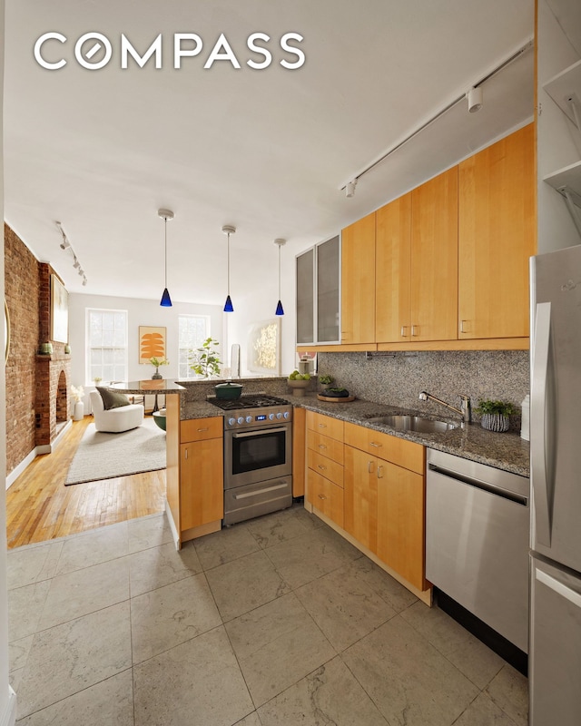 333 W 21st St Unit 2Fe, New York City, NY 10011 - kitchen with rail lighting, stainless steel appliances, a sink, a peninsula, and decorative backsplash
